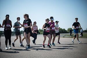 Eight running persons on Tempelhofer Feld in Berlin